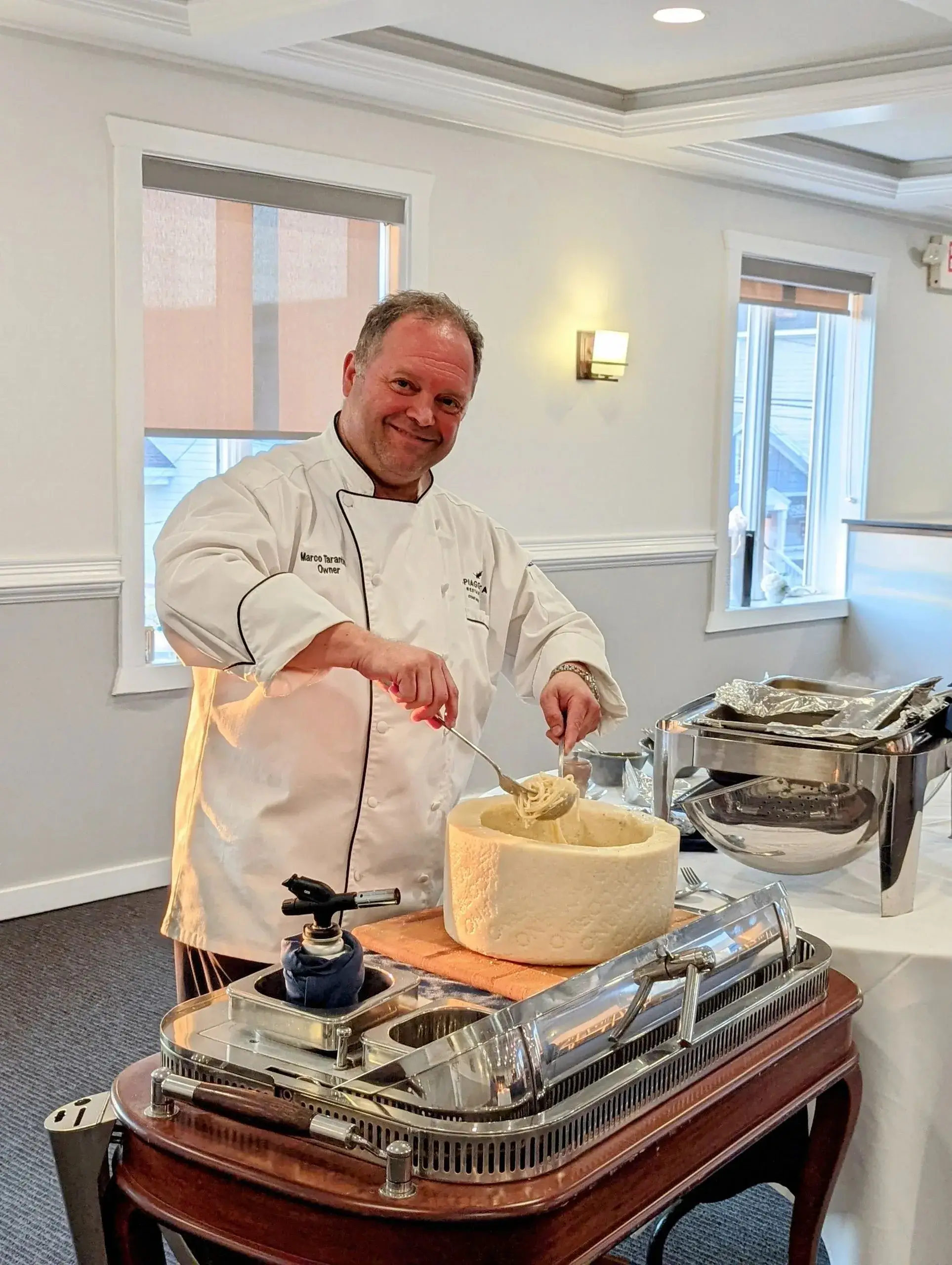 Chef preparing pasta in cheese wheel.